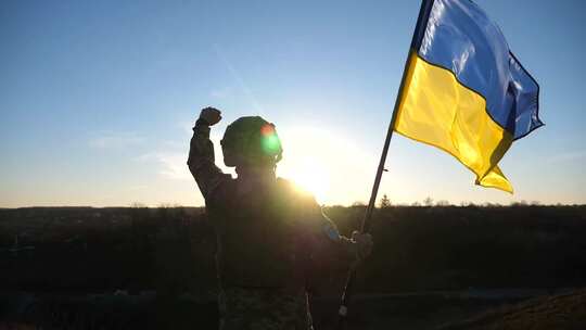 乌克兰军队士兵站在山上挥舞着乌克兰国旗