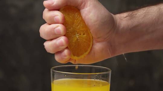 用手挤橙子到杯子里
