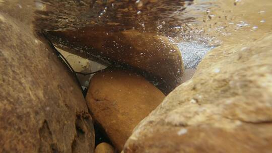 河水流经岩石激起水泡