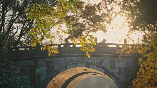 夕阳拱桥上行人车流逆光拍摄
