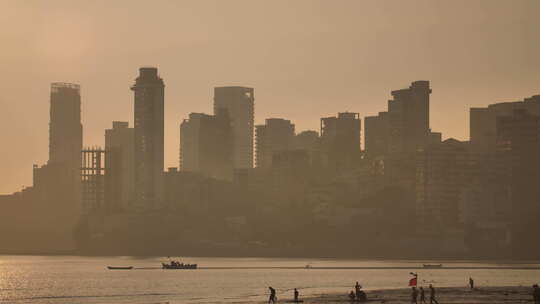 从乔帕蒂海滩看孟买摩天大楼背景下的日落