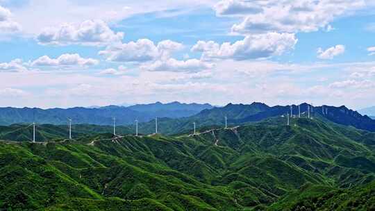 夏季绿色高山蓝天白云与风力发电机组