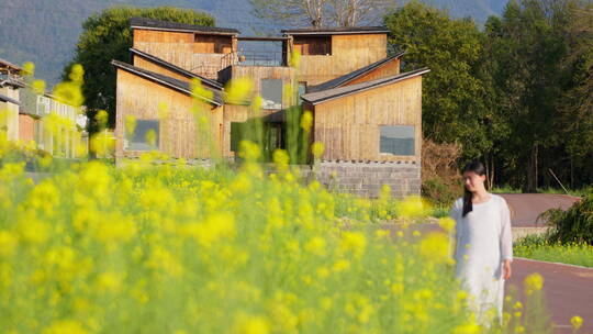 油菜花田中的美女和建筑