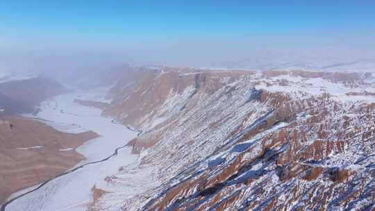 航拍新疆冬季安集海大峡谷红色山脉雪山河流