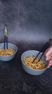 用筷子搅拌桌子上的面条