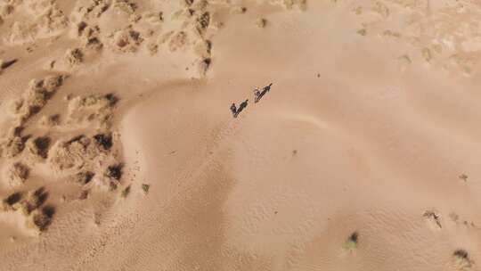 空中拍摄的人在沙丘上奔跑徒步