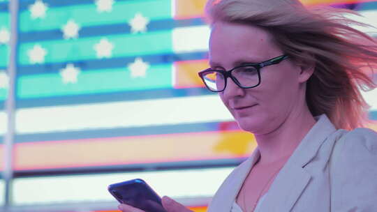 著名时代美国国旗背景下的女商人使用智能手机