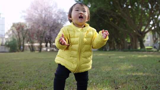 初学走路的可爱小女孩在公园里快乐玩耍