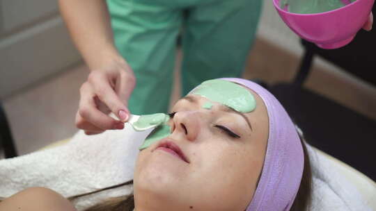女人在水疗中心做面膜。年轻女性在水疗沙龙