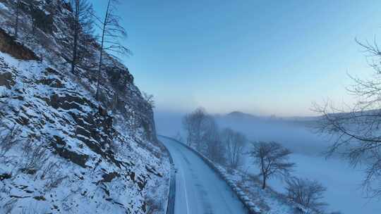 航拍冬季黎明林海雪原山路