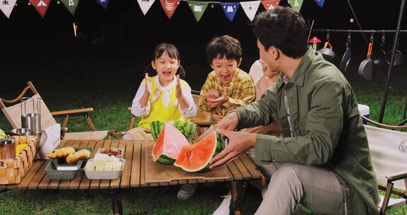 傍晚一家人在露营地吃西瓜做游戏