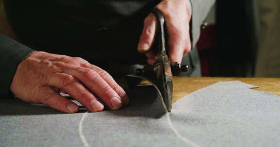 裁缝根据裁缝的传统绘制和切割布料。裁缝使