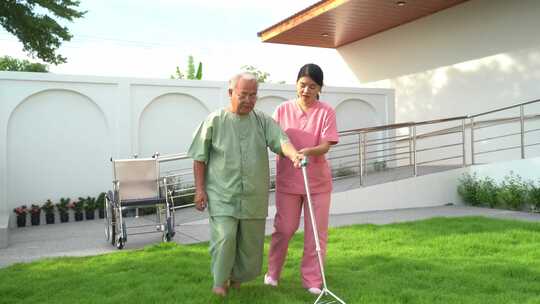 亚洲老年男性患者与护理人员一起做物理治疗视频素材模板下载