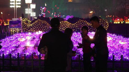春节期间一群人看灯会拍照游玩