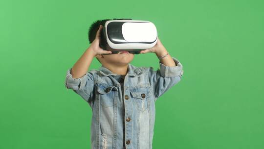 戴虚拟现实眼镜的小男孩绿屏