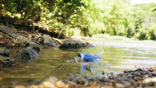 空铁罐漂浮在小溪上的慢镜头视频素材模板下载