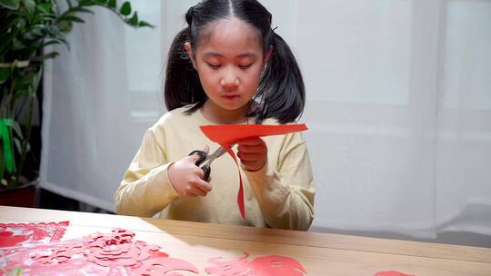 认真玩剪纸游戏的中国女孩