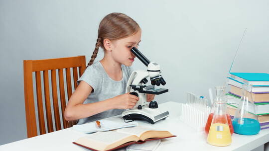 女学生使用显微镜做作业