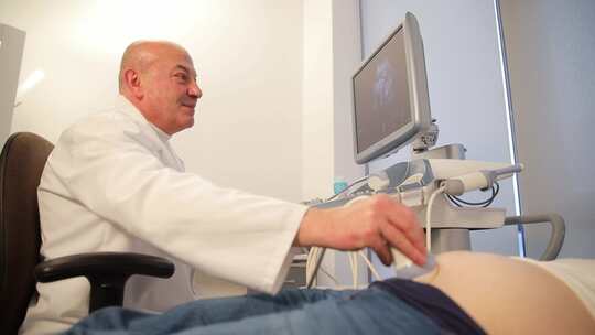 临床超声检查中男医生为孕妇做超声检查的侧视频素材模板下载