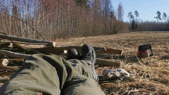 伐木工人的POV在一堆树枝旁边休息，在阳