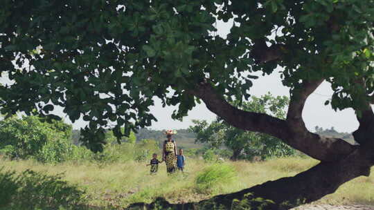非洲女人头顶蔬菜篮子接孩子放学回家