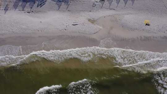 从空中俯瞰海湾水波撞击海滩的白色沙滩