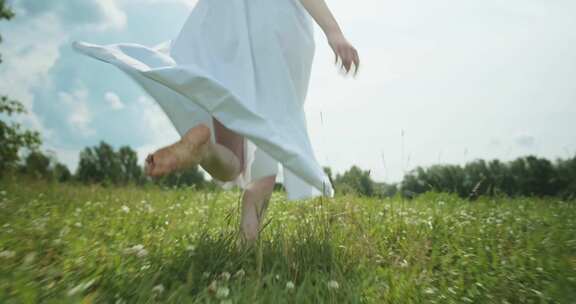 光着脚的女孩在草地上自由的奔跑