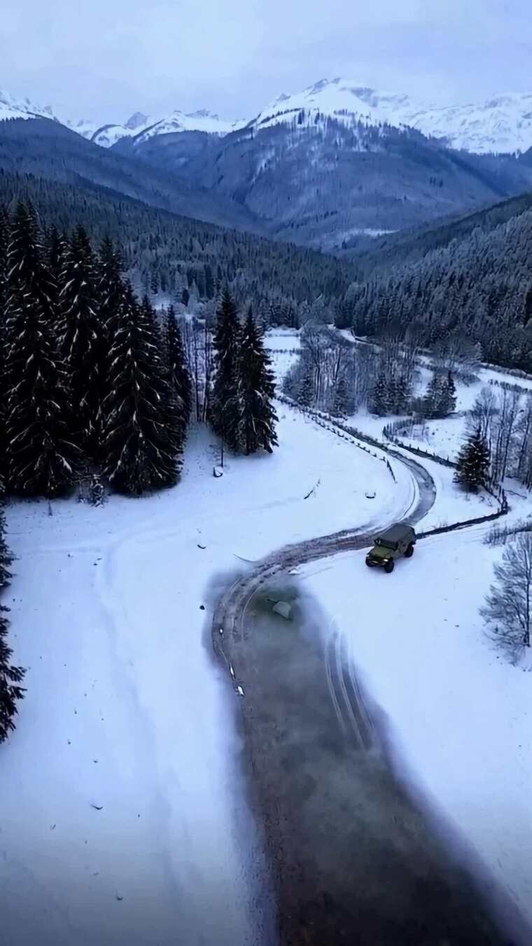 雪地山路行驶的越野车