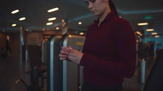 女人在健身房戴上耳机的特写视频素材模板下载