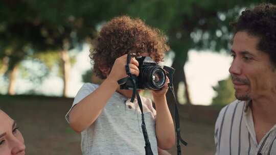 一个小男孩用数码单反相机拍照