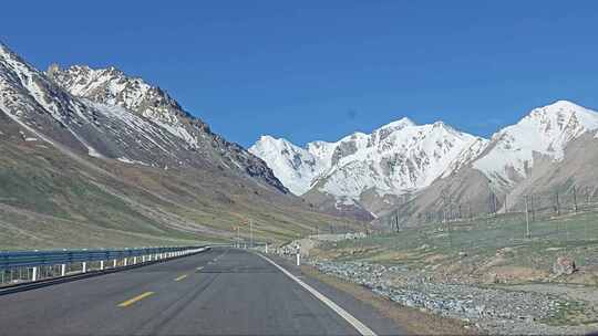开车在新疆两边是雪山的公路上车窗外风景