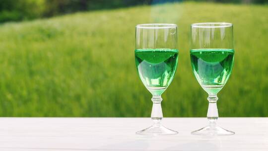 绿色草坪背景上的两杯绿色饮料