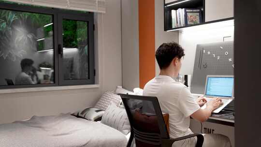 男生在卧室玩笔记本学习电脑编程视频素材模板下载