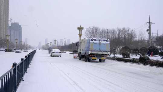 4k北方城市下大雪的马路上的除雪车除雪