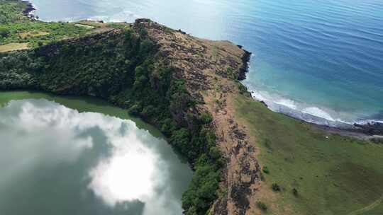 鸟瞰火山口湖，绿色的水被悬崖和绿色植物包