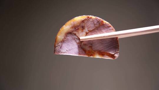 筷子夹起一片熟食卤肉