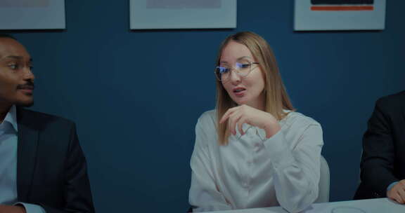戴眼镜的女人在商务会议上与同事交谈办公室里的肖像