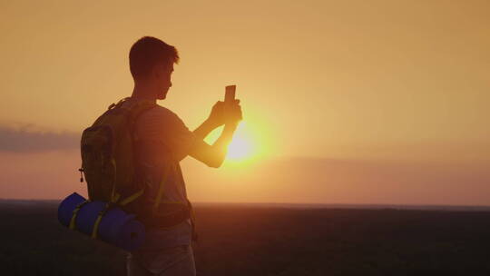 年轻人在落日下拍风景视频素材模板下载