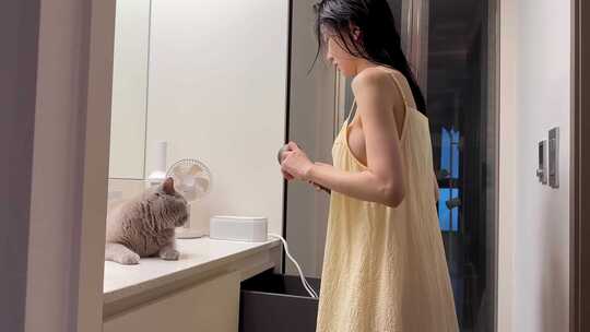 美女吹头发美女洗澡后在镜子前吹头发逗猫视频素材模板下载