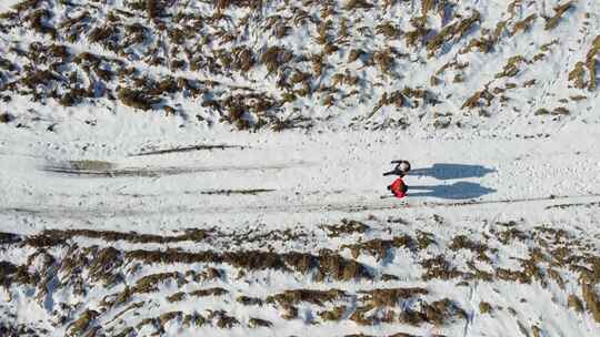 航拍两个人在雪地里行走