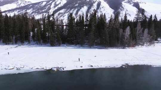 航拍新疆阿勒泰冬季喀纳斯游客在雪地上游玩