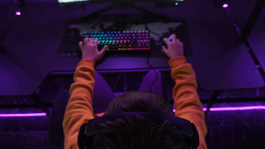 年轻玩家坐在游戏椅上，在电子竞技俱乐部玩