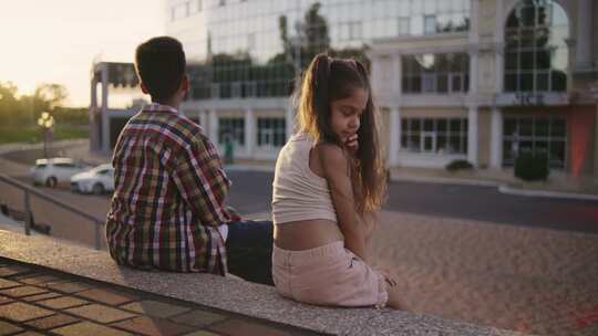 坐在户外的孩子们在城市环境中享受一个放松