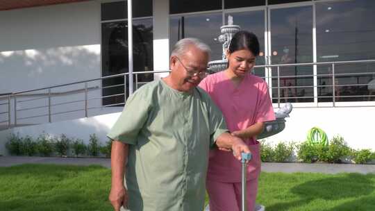 亚洲老年男性患者在护理人员女护士的帮助下