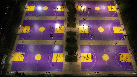 航拍城市夜晚灯光篮球场上运动健身的人群