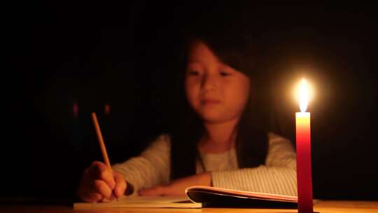 写作业晚上烛光小学生刻苦学习做题写字蜡烛