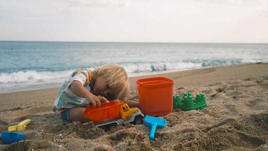 一个孩子在海滩沙滩上玩玩具
