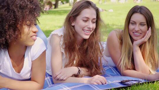 女孩开心的趴在草坪上聊天视频素材模板下载