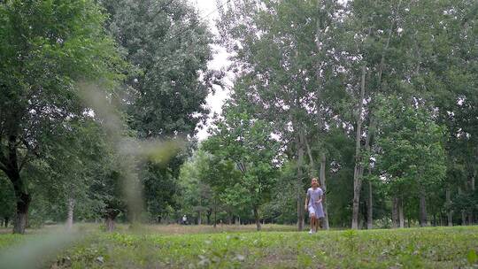 在公园树林奔跑玩耍东方女孩