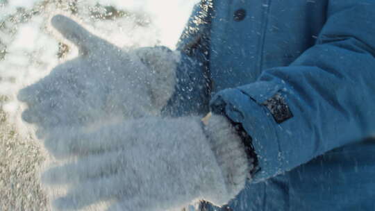 匿名孩子抖掉羊毛手套上的雪的慢动作